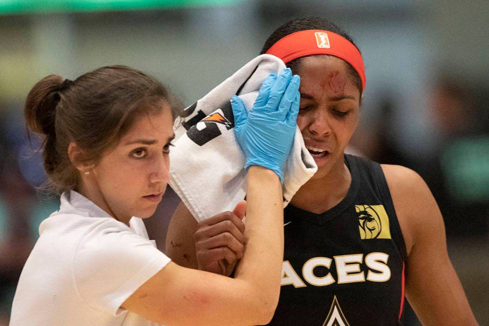 Las Vegas Aces' Sydney Colson, right, is led off the court after being injured in the first qua ...