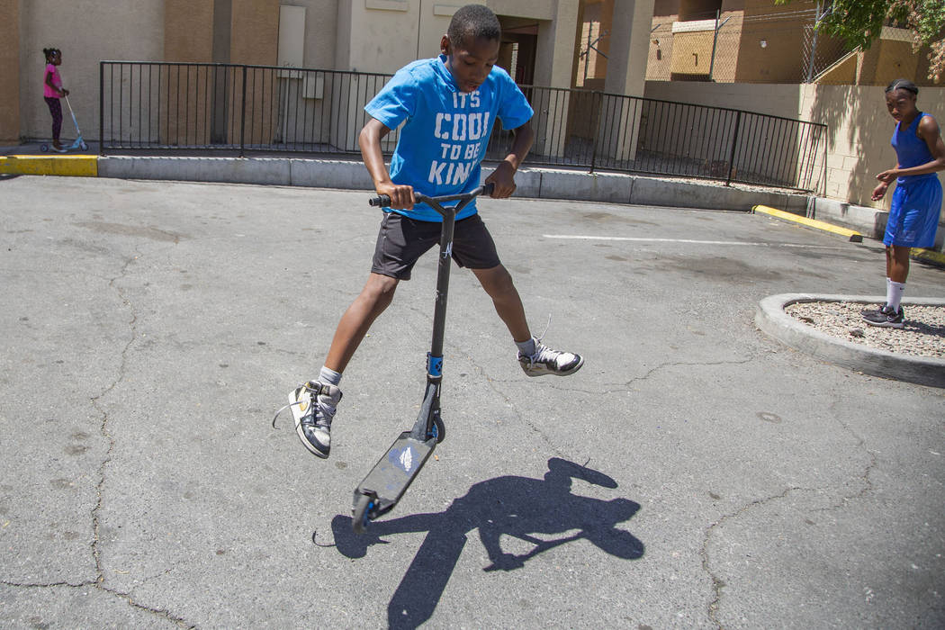 Devon Brown, 9, of North Las Vegas does a trick on his scooter during a summer day at Nellis Su ...
