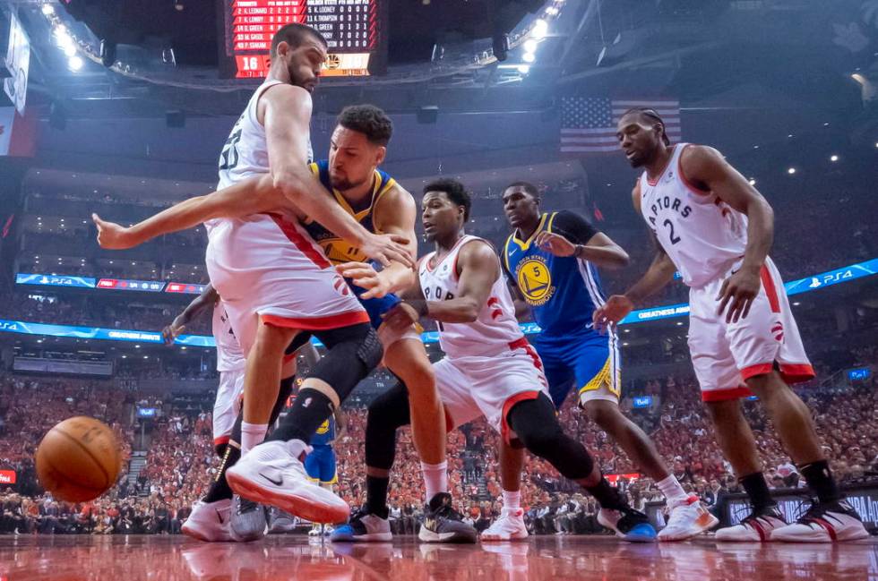 Golden State Warriors guard Klay Thompson (11) reaches for the ball past Toronto Raptors' Marc ...