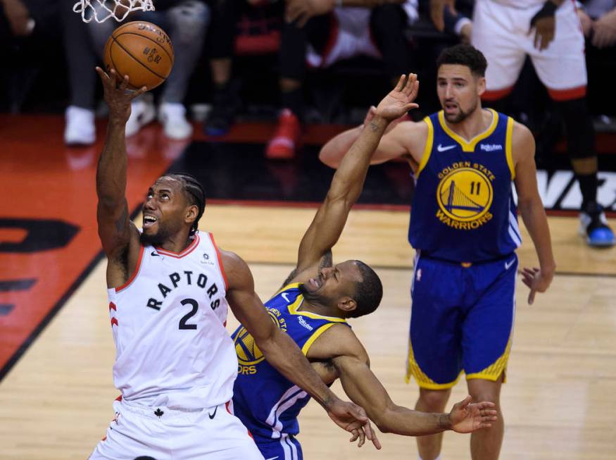 Toronto Raptors forward Kawhi Leonard (2) drives past Golden State Warriors forward Andre Iguod ...