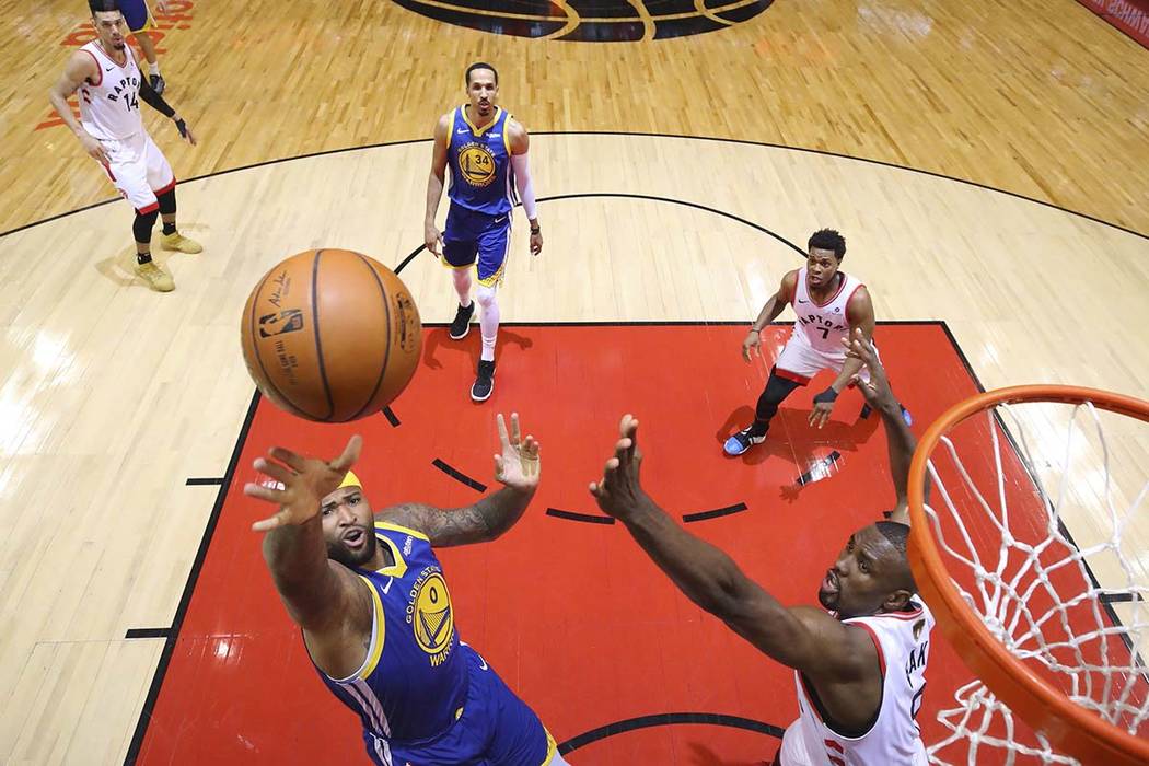 Golden State Warriors center DeMarcus Cousins (0) drives to the net past Toronto Raptors center ...