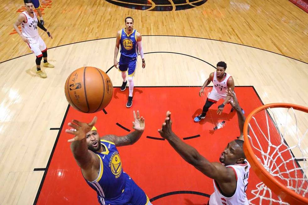 Golden State Warriors center DeMarcus Cousins (0) drives to the net past Toronto Raptors center ...