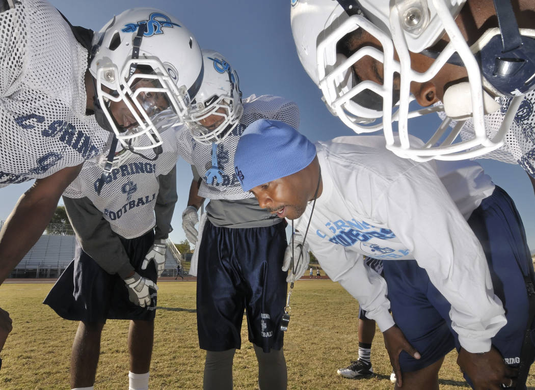 Canyon Springs High School head football coach Hernandez "Hunkie" Cooper, in blue cap, gives hi ...
