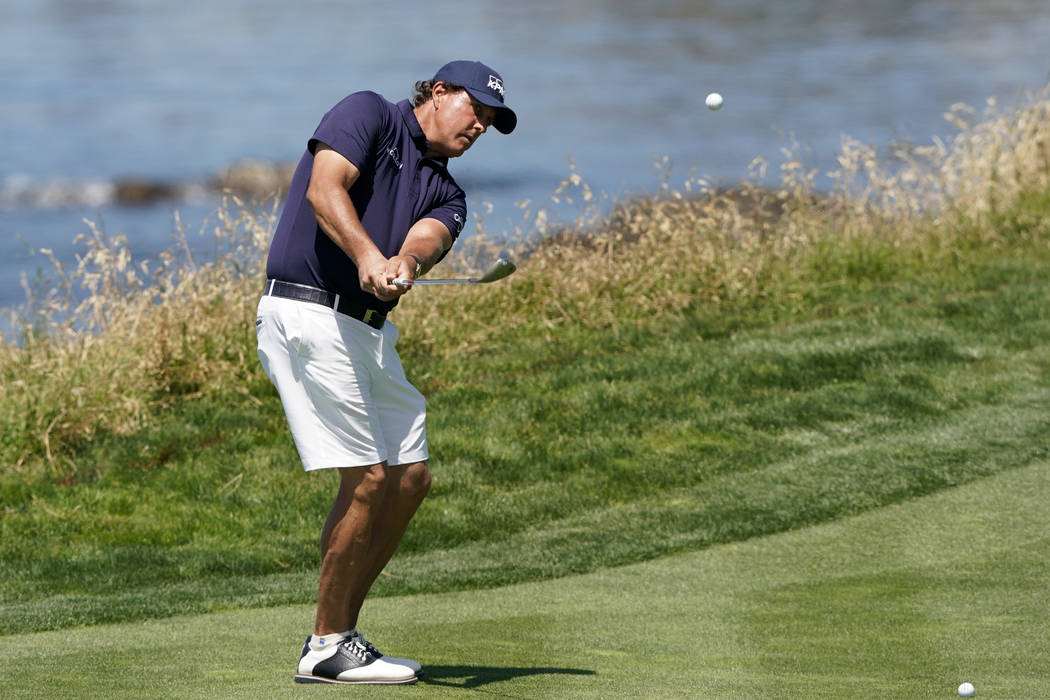 Phil Mickelson hits a chip shot on the ninth hole during a practice round for the U.S. Open Cha ...