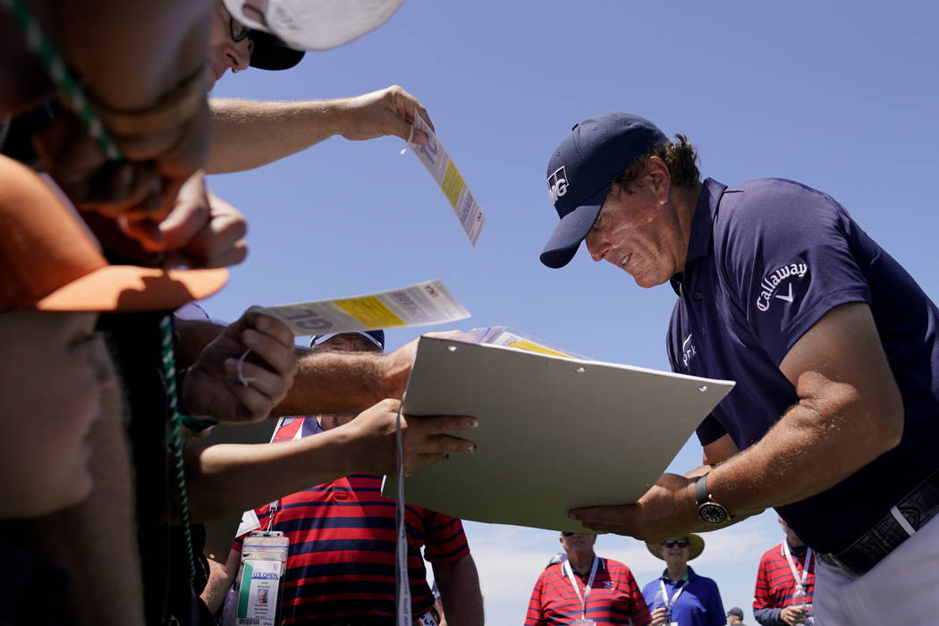 Phil Mickelson signs autographs after a practice round for the U.S. Open Championship golf tour ...