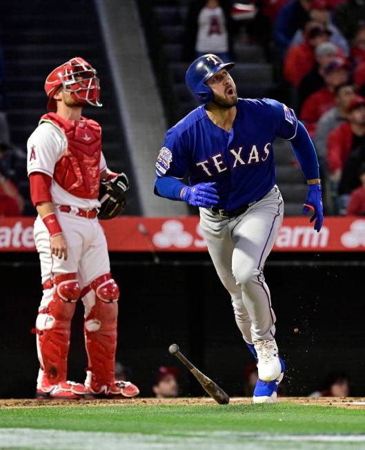 Texas Rangers' Joey Gallo heads to first on a three-run home run, next to Los Angeles Angels ca ...