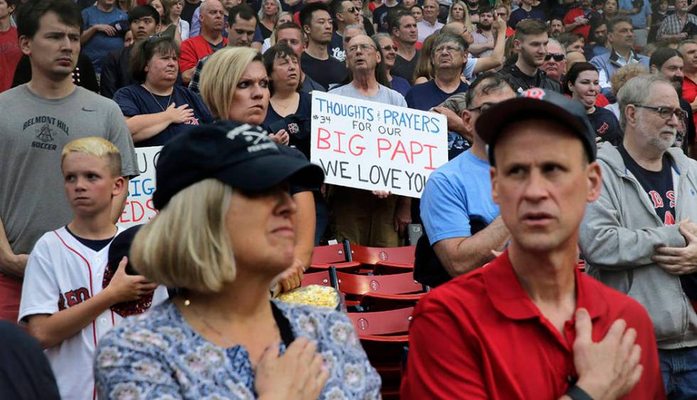 A fan holds a sign sending thought and prayers to former Boston Red Sox designated hitter David ...