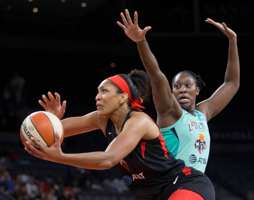 Las Vegas Aces center A'ja Wilson (22) slashes to the rim past New York Liberty center Tina Cha ...