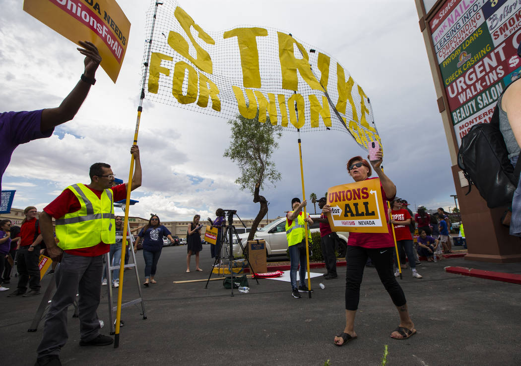 Lupe Guzman, of Las Vegas, right, holds a sign while chanting during a protest in support of hi ...