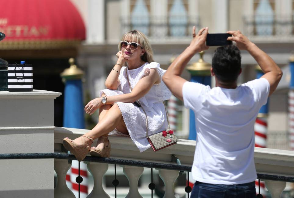 Lana Corrales poses for her husband Eric, both of Los Angeles, outside The Venetian on Friday, ...