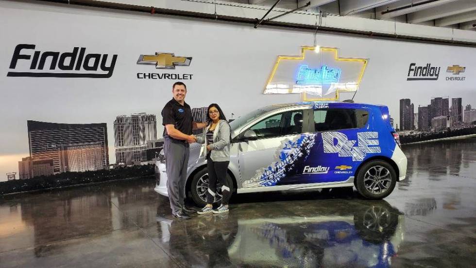 Findlay Chevrolet General Manager Doug Fleming congratulates Clark High School graduate Angela ...