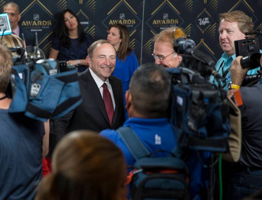 NHL commissioner Gary Bettman, left, talks with media on the red carpet before the start of the ...