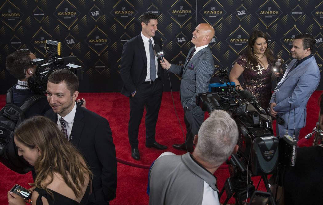Pittsburgh Penguins center Sidney Crosby, top/middle, talks with media on the red carpet before ...