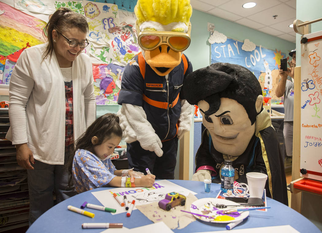 Nilda Campos, left, helps her granddaughter Zaryah Robbs, 8, draw a picture with Aviator mascot ...