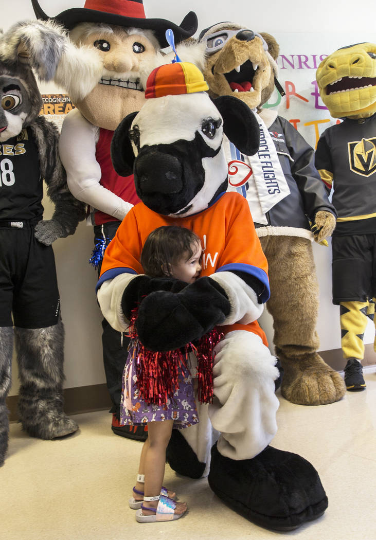 Camila Silva, 2, hugs the Chick-fil-A Cow during a welcome event for Miles the Miracle Flights ...
