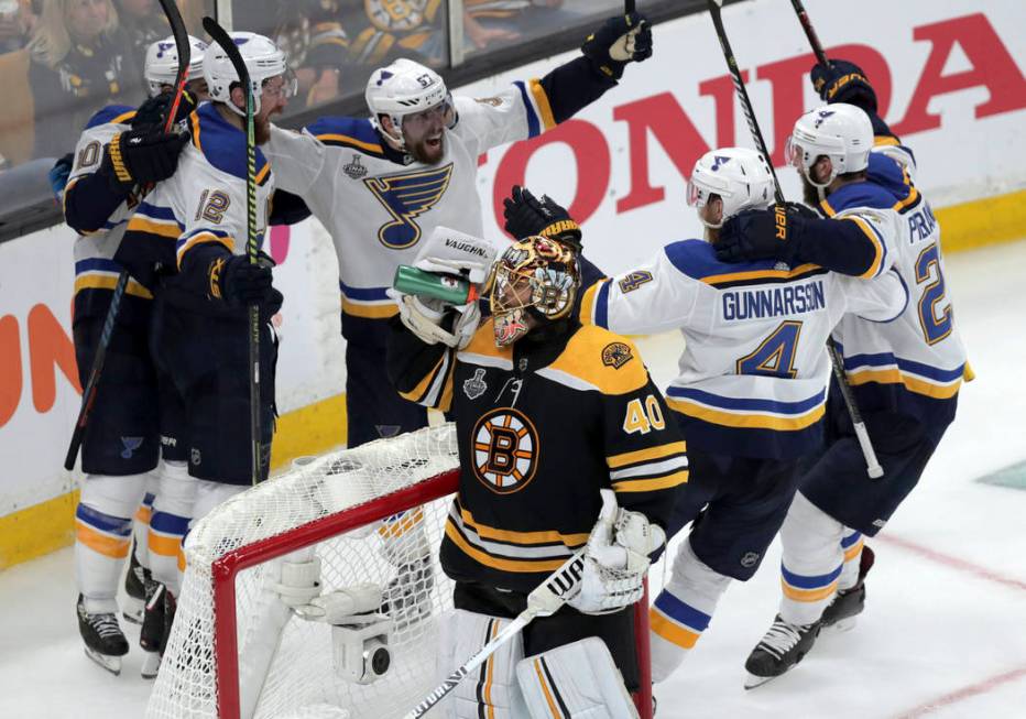 St. Louis Blues' Zach Sanford (12) celebrates his goal with teammates behind Boston Bruins goal ...