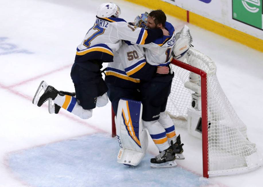 St. Louis Blues' Jaden Schwartz, left, and Brayden Schenn, right, mob goaltender Jordan Binning ...