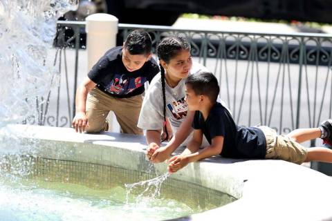 Children cool themselves at The Venetian water fountain on the Las Vegas Strip. Tempe ...