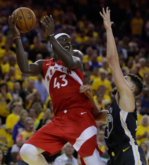 Toronto Raptors' Pascal Siakam, left, looks to pass away from Golden State Warriors' Klay Thomp ...