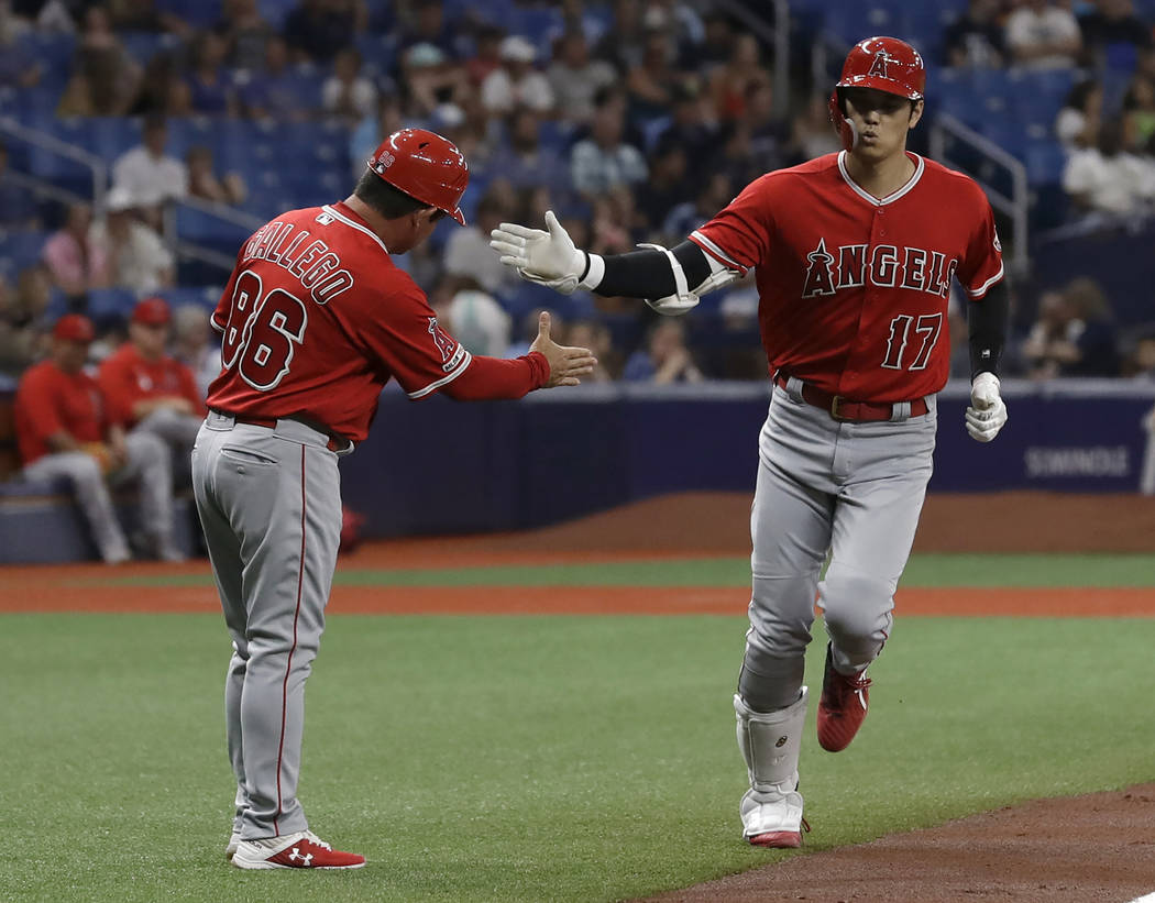 Los Angeles Angels' Shohei Ohtani (17), of Japan, shakes hands with third base coach Mike Galle ...