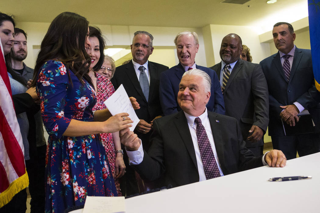 Gov. Steve Sisolak hands bill AB291, which includes a variety of gun control regulations, inclu ...