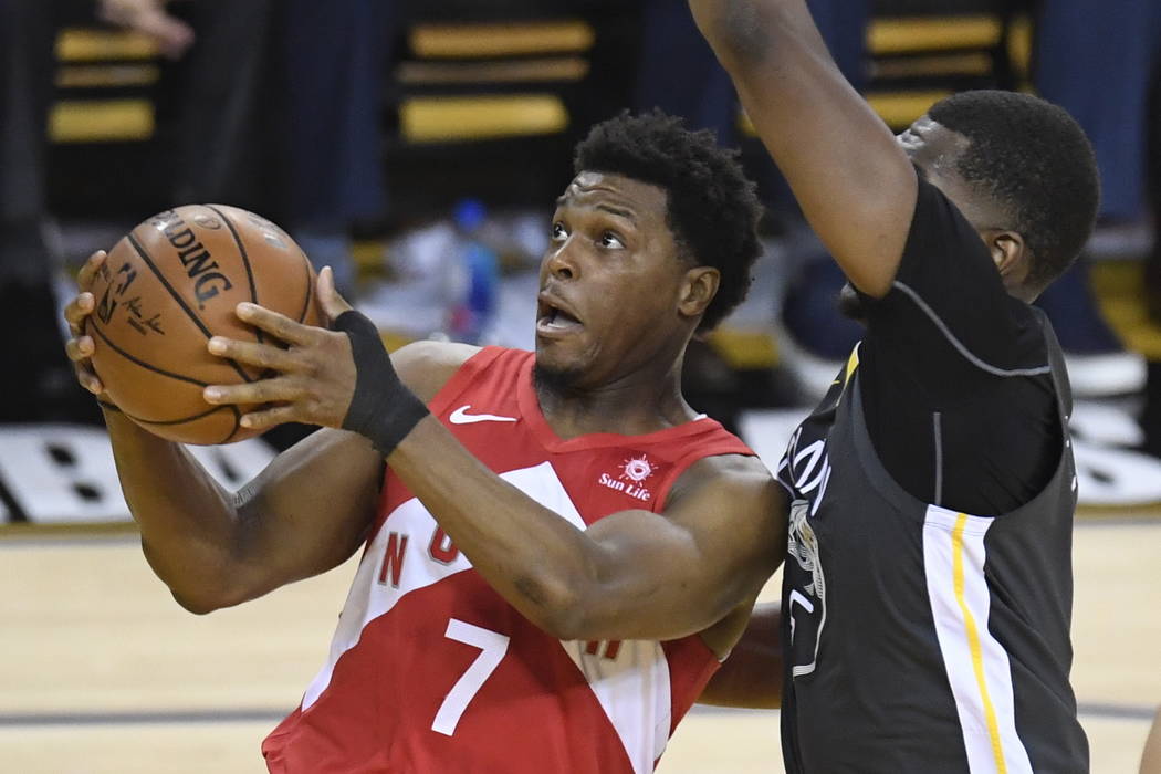 Toronto Raptors guard Kyle Lowry (7) gets off a shot in front of Golden State Warriors centre K ...