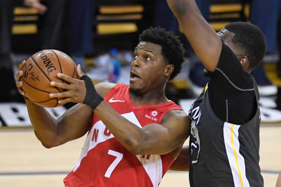 Toronto Raptors guard Kyle Lowry (7) gets off a shot in front of Golden State Warriors centre K ...