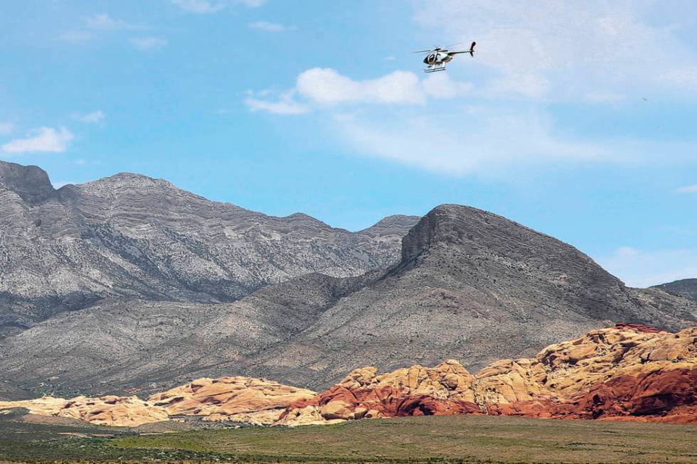 A helicopter flies near the Red Rock Overlook on U.S. Highway 159 in Red Rock Canyon National C ...