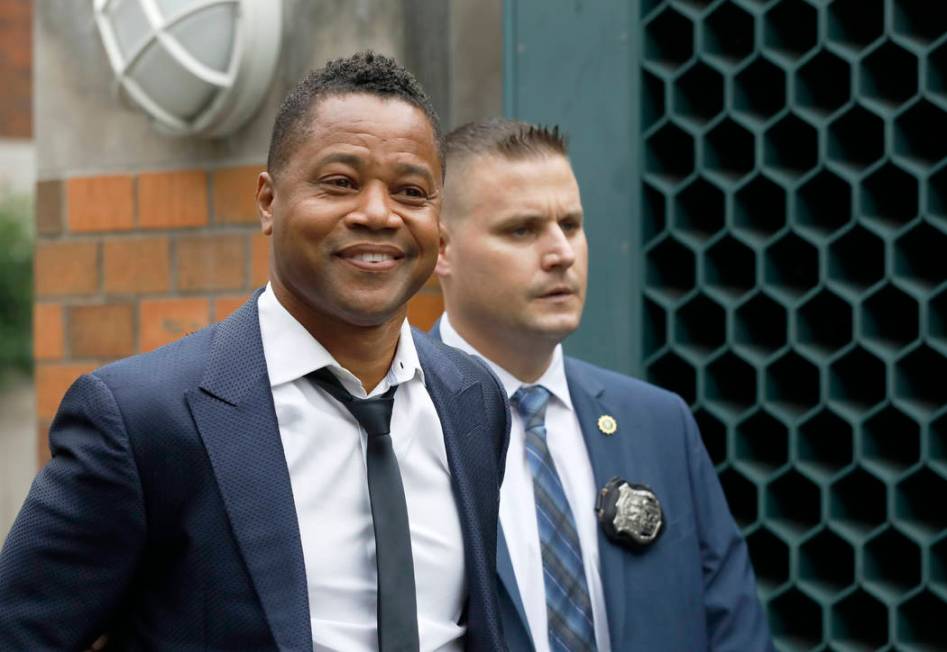 Actor Cuba Gooding Jr., left, is lead by a police officer from New York's Special Victim's Unit ...