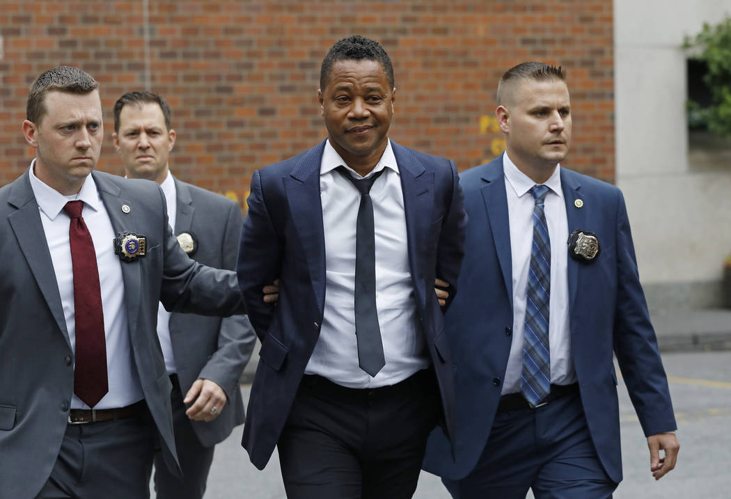 Actor Cuba Gooding Jr., center, is lead by police officers from the New York Police Department' ...