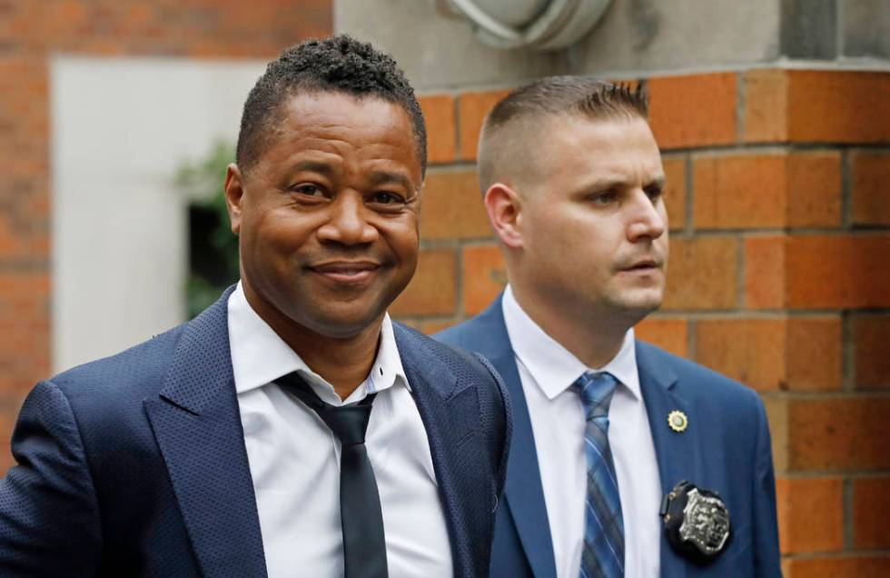 Actor Cuba Gooding Jr., left, is lead by a police officer from New York's Special Victim's Unit ...