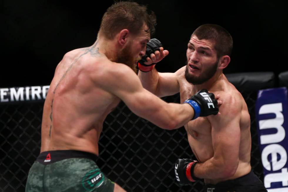 Conor McGregor, left, fights Khabib Nurmagomedov during their lightweight title bout at UFC 229 ...