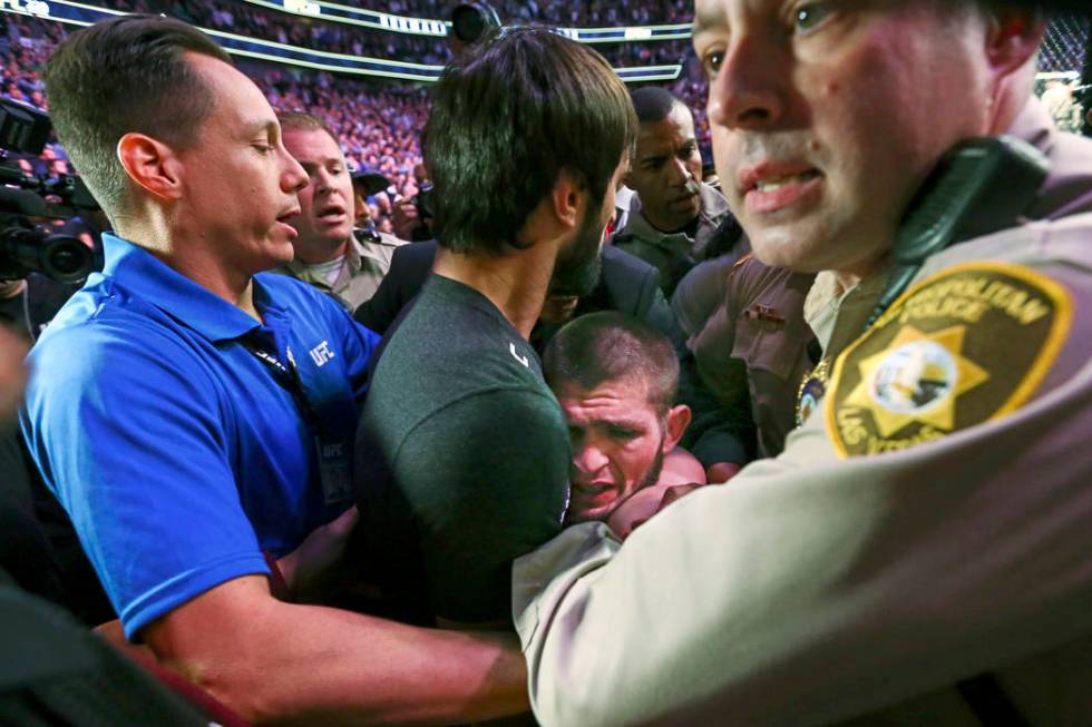 Khabib Nurmagomedov is restrained outside of the octagon after he defeated Conor McGregor at UF ...