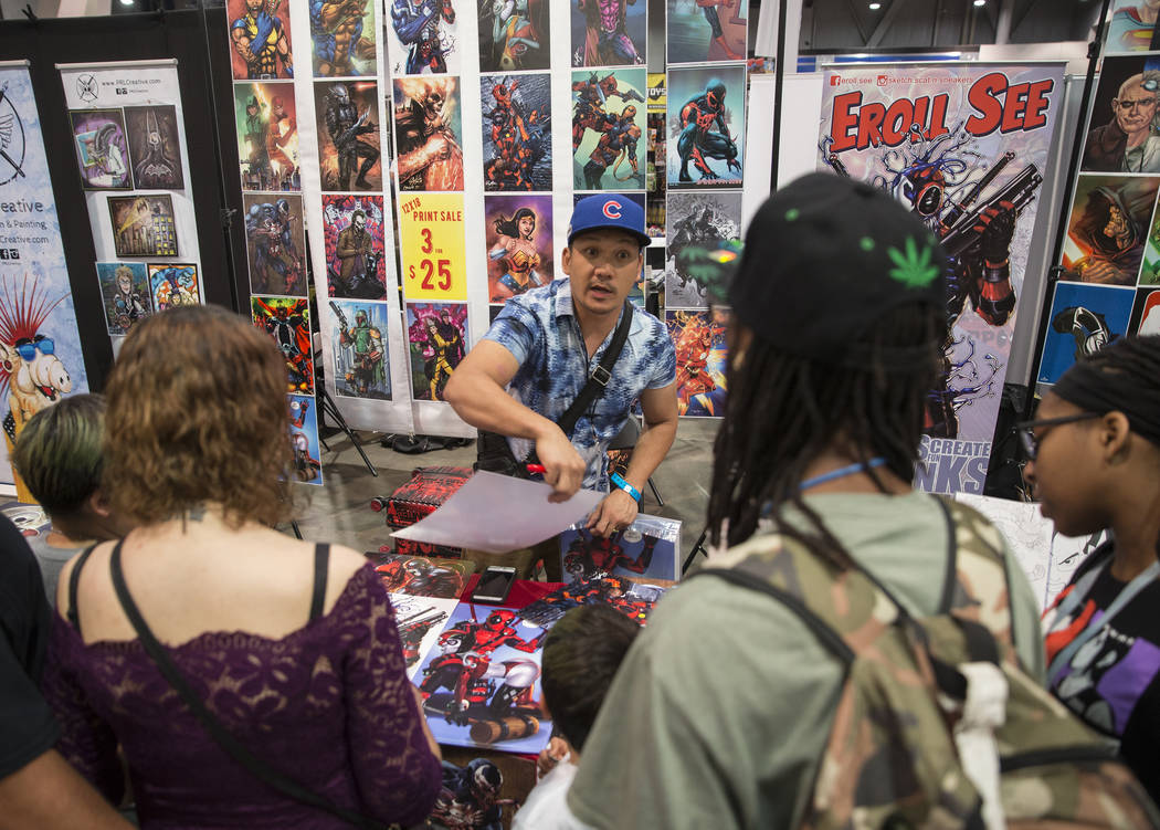 Artist Eroll See, center, sells prints during the Amazing Las Vegas Comic Con on Friday, June 1 ...