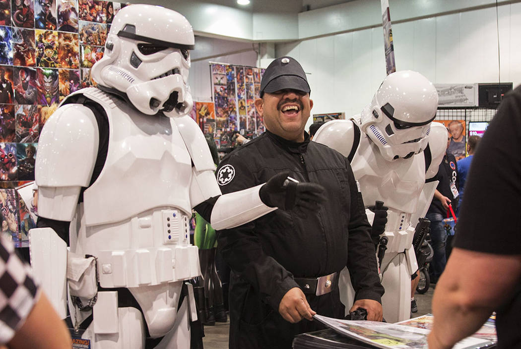 Jathniel Velazquez, center, shares a laugh with a pair of stormtroopers while looking at comic ...