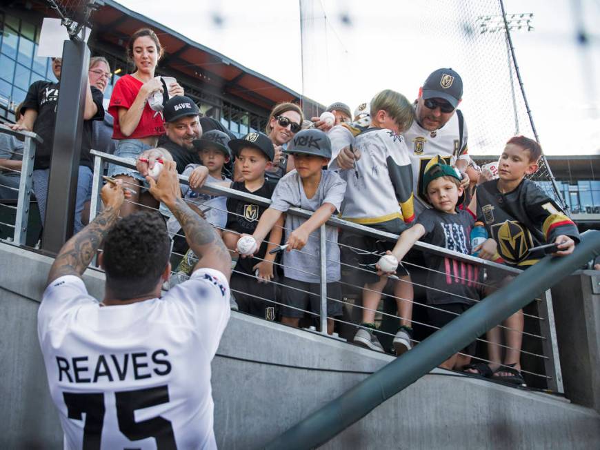 Golden Knights right wing Ryan Reaves, left, signs autographs before the start of the Battle Fo ...