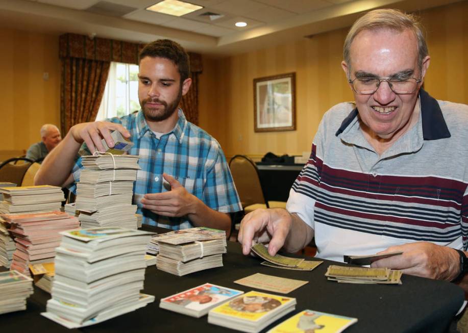 Reuben Lewin, left, and Glenn Sulser, sports cards appraisers, sort out valuable sports cards o ...