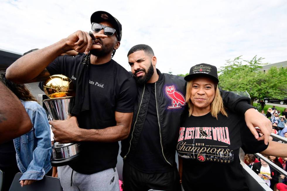 Toronto Raptors forward Kawhi Leonard, left to right, smokes a cigar holding his playoffs MVP t ...