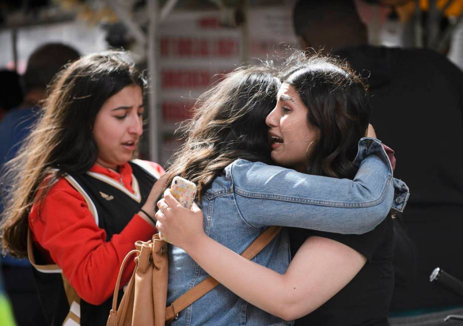 Friends embrace after shots were fired during the Toronto Raptors NBA basketball championship p ...