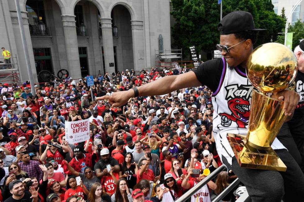 Toronto Raptors guard Kyle Lowry gestures towards fans while holding the Larry O'Brien Champion ...