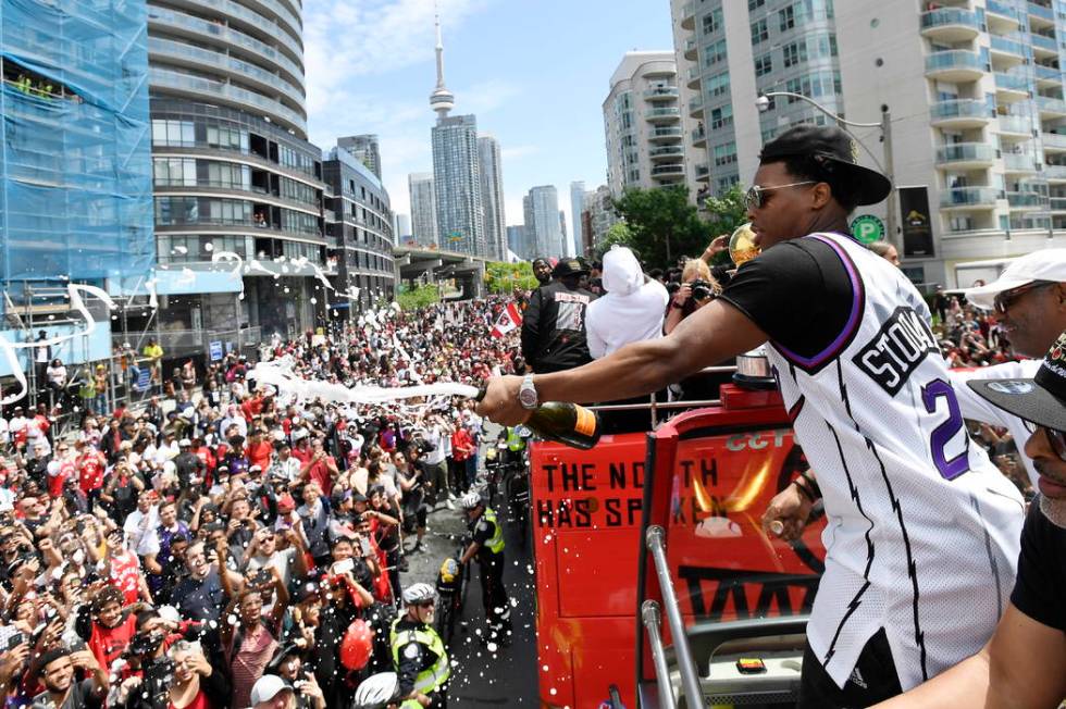 Toronto Raptors guard Kyle Lowry sprays champagne towards fans during the NBA basketball champi ...