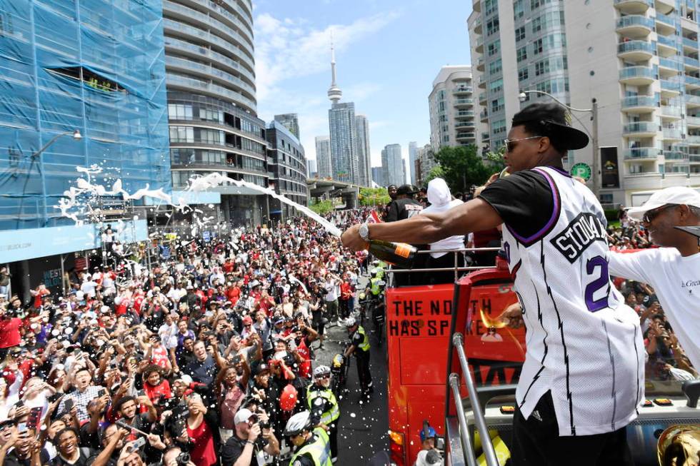 Toronto Raptors guard Kyle Lowry sprays champagne on fans during the NBA basketball championshi ...