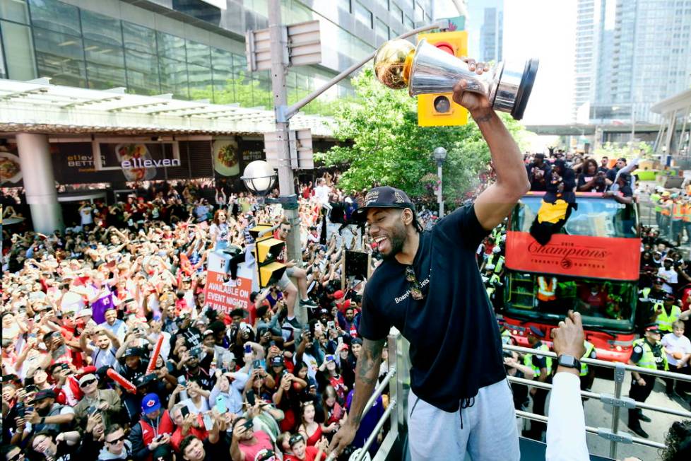 Toronto Raptors forward Kawhi Leonard hoists his playoffs MVP trophy during the NBA basketball ...