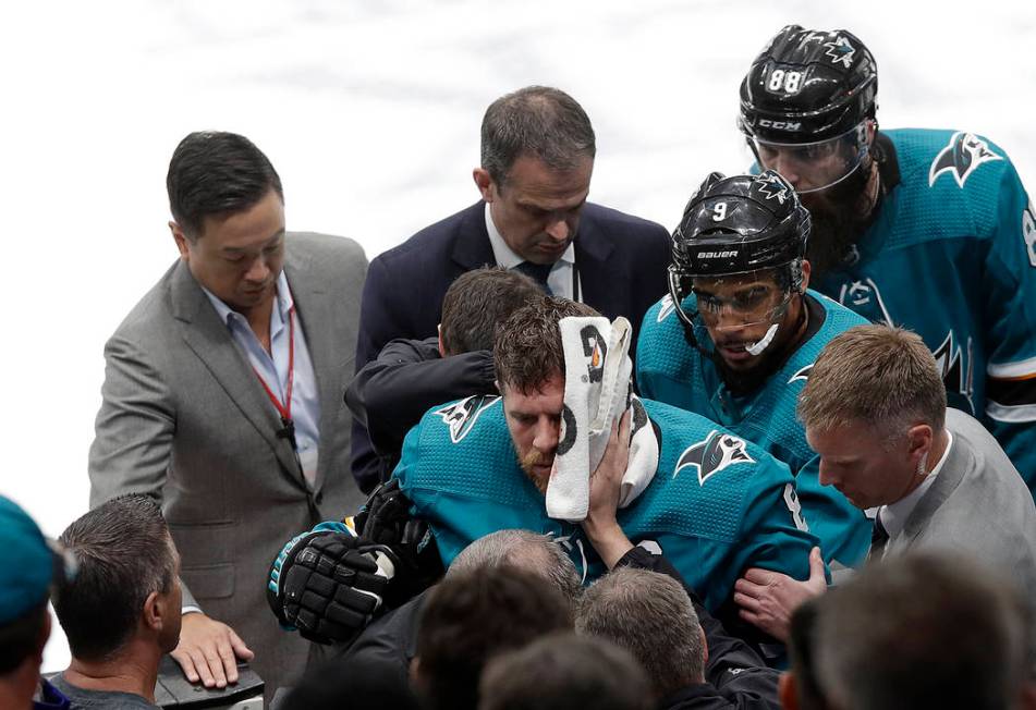 San Jose Sharks center Joe Pavelski, bottom center, is helped off the ice during the third peri ...