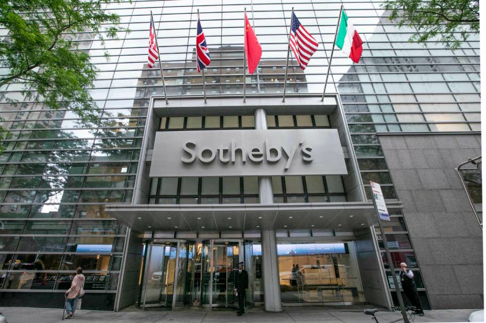 Flags fly on the front of Sotheby's auction house, in New York, Monday, June 17, 2019. BidFair ...