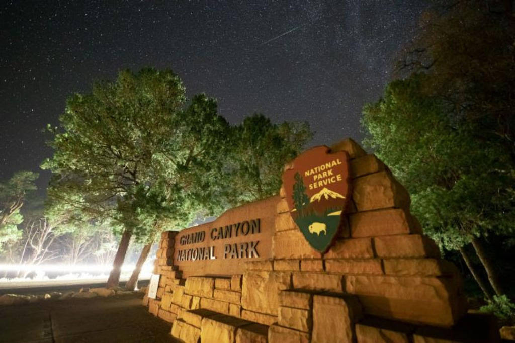 A meteor streaks through the sky above the entrance to Grand Canyon National Park, which was ju ...