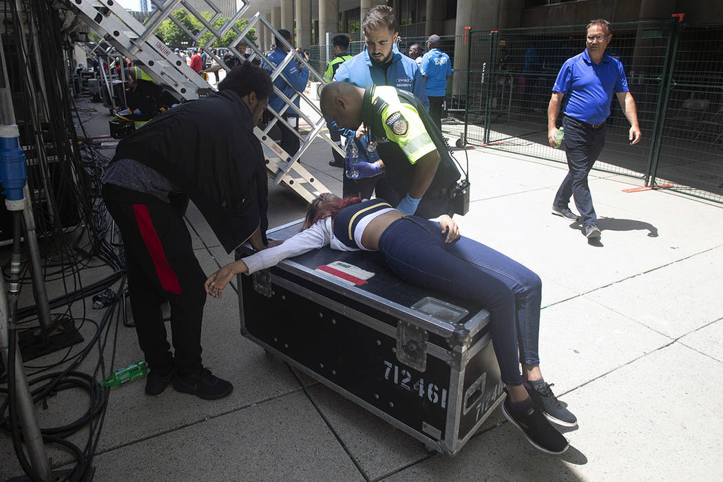 A woman is treated by a paramedic after being pulled from the crowd during the Toronto Raptors ...