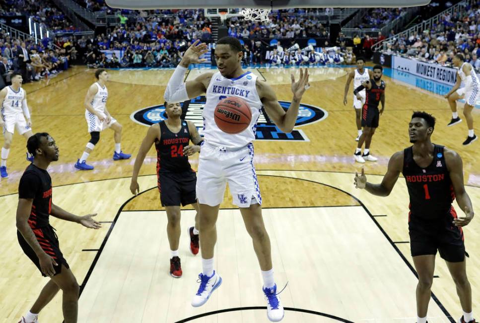 Kentucky's PJ Washington dunks as Houston's DeJon Jarreau, left, Breaon Brady (24) and Chris Ha ...