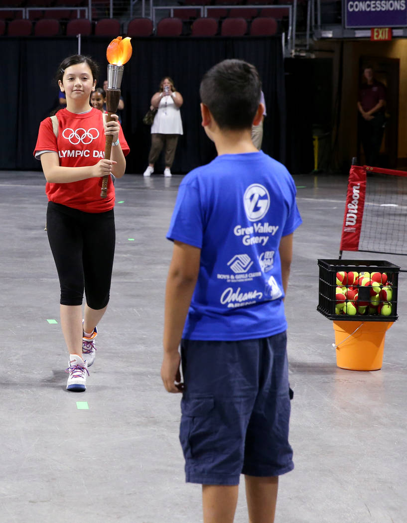 Bianca Perez, 11, of Lied Boys & Girls Club prepares to pass the torch to Brandon Paz, 10, ...