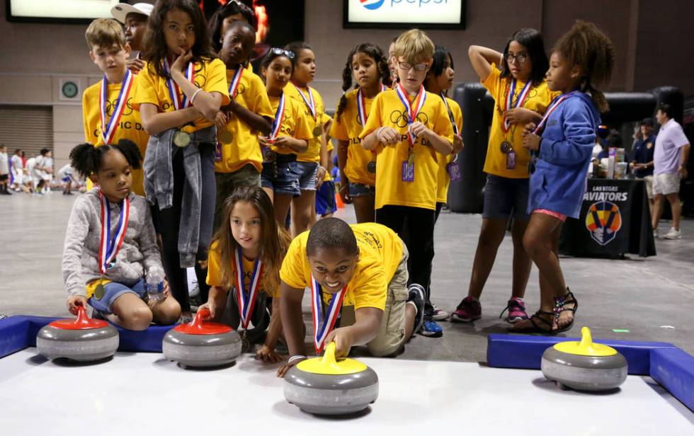 Ishmael Edwards, 10, of John D. "Jackie" Gaughan Boys & Girls Club tries curling on Olympic Day ...